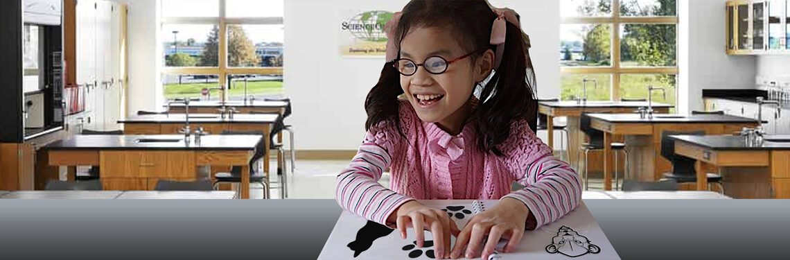Student exploring tactile reading material at a desk.